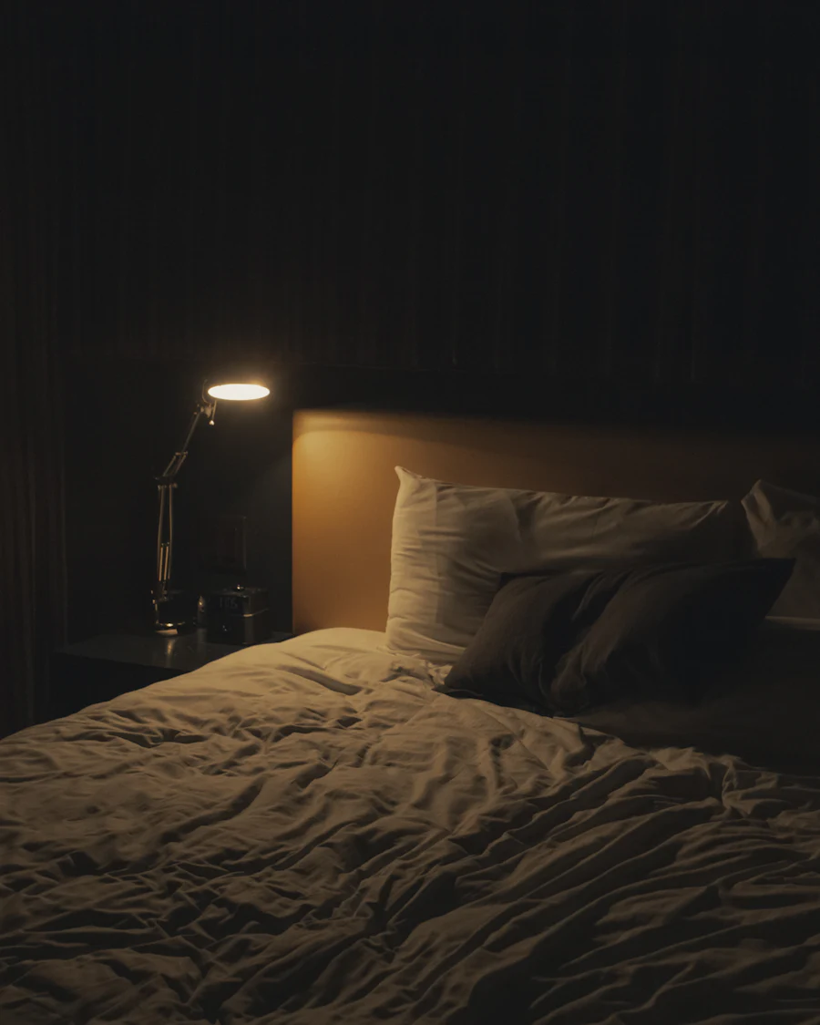 Una habitación a oscuras iluminada solo por una lámpara de mesa.